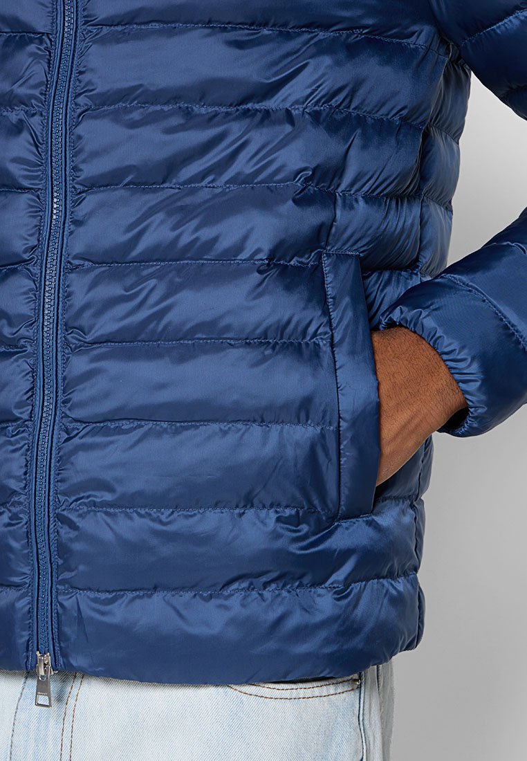 Granatowa kurtka puchowa z poziomymi pikowanymi sekcjami, z zapięciem na zamek błyskawiczny z przodu i bocznymi kieszeniami, wykonana z gładkiego, błyszczącego materiału nylonowego.
