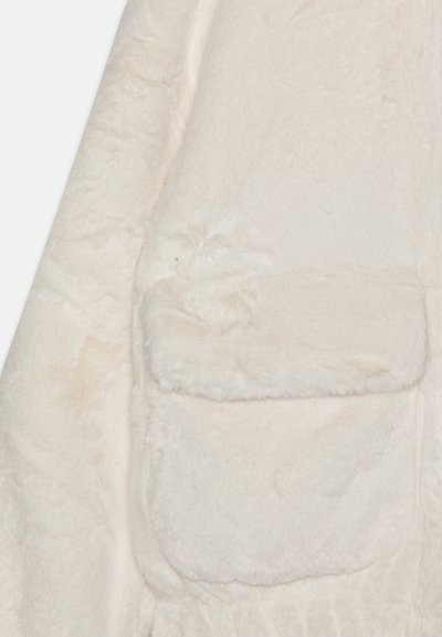 Tissu en fausse fourrure douce de couleur blanc cassé, avec une poche rectangulaire en peluche dotée d'un rabat sur la zone des manches d'un vêtement.
