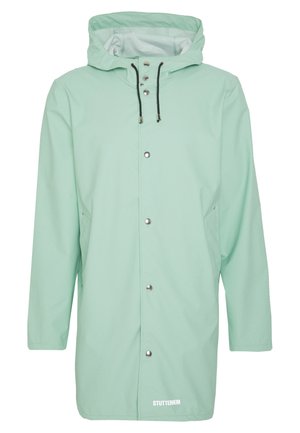 Vaaleanvihreä huppullinen sadetakki, jossa edessä painonapit, mustat säädettävät kiristysnauhat ja sivutaskut, Stutterheim-logo alareunassa edessä.