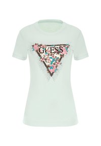Světle modré bavlněné tričko s květinovým trojúhelníkovým logem a textem "GUESS." Krátké rukávy a kulatý výstřih, hladká textura.