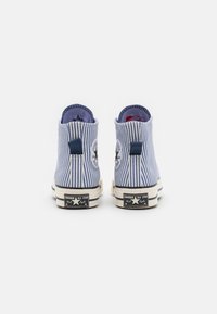 Blå og hvite stripete lerrets høye sneakers med logo-patch, hvite gummisåler og marineblå detaljer på kragen og hælen.