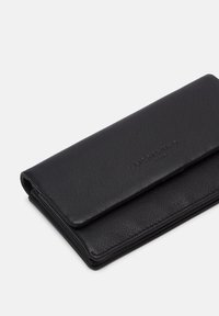 Czarny skórzany portfel o fakturowanej powierzchni, wyposażony w klapkę zamykaną i wytłoczone logo na przedniej części. Kompaktowy, prostokątny kształt.