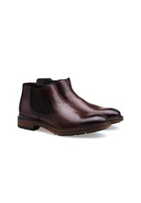 Botas de tobillo de cuero marrón con paneles laterales elásticos, punta redondeada y suelas texturizadas. El acabado es suave con un ligero brillo.