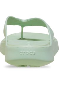 Zielone sandały Crocs z miękkim, teksturowanym paskiem, płaską wkładką i wypukłym logo na podeszwie. Prosty, wsuwany design z szerokim otworem na palce.