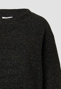 Schwarzer strukturierter Pullover mit gesprenkeltem Design, rundem Ausschnitt und lockerer Passform. Das Material wirkt weich mit einem leichten Glanz.