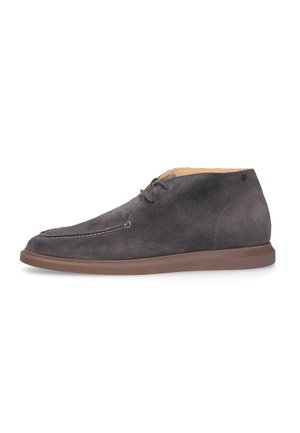 Polacchino da uomo in suede grigio scuro con suola in gomma marrone e chiusura frontale con lacci, mostrato di profilo su sfondo bianco.