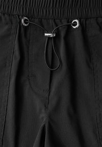 Pantaloni corti neri realizzati in tessuto leggero, dotati di una vita elasticizzata e di un cordoncino nero che passa attraverso occhielli metallici. Include cuciture laterali.