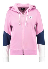Felpa rosa con zip, maniche a motivo blu e bianco, cappuccio con cordino e patch rotondo con logo. Realizzata in materiale morbido e traspirante.
