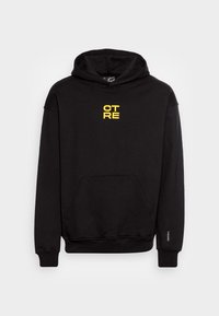 Felpa nera realizzata in tessuto misto cotone con tasca frontale. Presenta una scritta gialla "CTRE" centrata sul petto. Cappuccio con cordino.