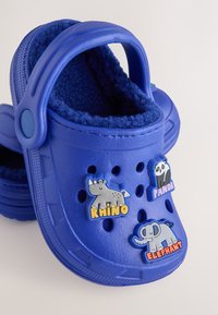 Sinised plastist klotskingad pehme ja tekstuuriga siseosaga; kaunistatud loomateemaliste märkidega: ninasarvik, panda ja elevant. Sisaldab ventilatsiooniavasid.