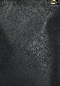 Zwarte leren tas met textuur, voorzien van gouden accenten op de hardware, een glad oppervlak met subtiele nerfdetails en een gestructureerd maar flexibel ontwerp.