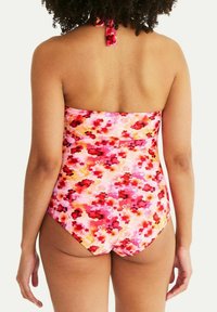 Blomstermönstrad baddräkt i nyanser av rosa, röd och orange; axelbandslös design med knytning bak; slät textur och figurnära passform.