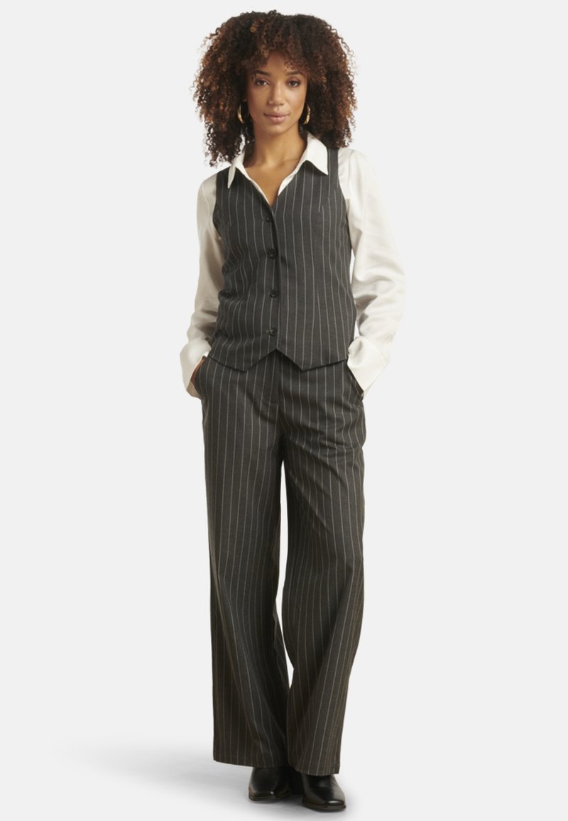 Gray pinstriped vest and matching wide-leg trousers, paired with a white button-up shirt. The outfit features a tailored design and textured fabric.