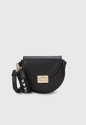 Mustanpuolikuun muotoinen nahkainen olkalaukku, jossa on kultainen solki ja säädettävä mustavalkoinen kuvioitu kangashihna, yksivärisellä taustalla.