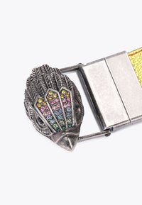 Metalen riemgesp in de vorm van een vogelkop, versierd met gekleurde kristallen en ingewikkelde veerdetails. Gele gevlochten band.