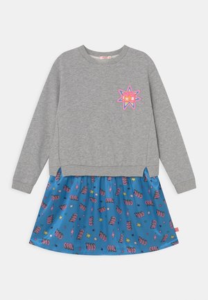 Grå sweatshirt med ribbede manchetter; blå nederdel med farverig "COOL" tekst, stjerner og lyn-mønstre.