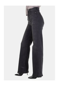 Jeans a vita alta e gamba larga in denim grigio scuro. Presentano una chiusura con bottoni, un design con cinque tasche e un orlo leggermente consumato.