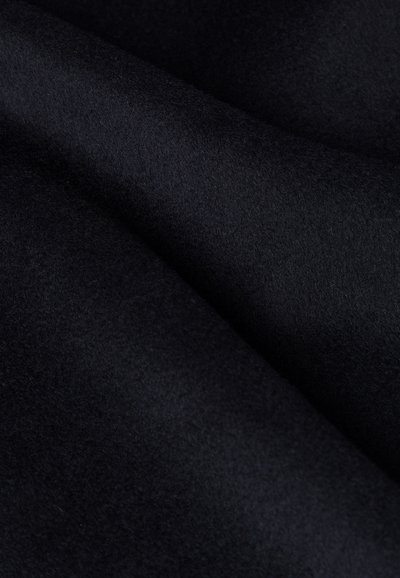 Czarna, miękka tkanina wełniana o gładkiej fakturze, prezentująca subtelne różnice w odcieniu i głębokości. Powierzchnia wydaje się ciepła i zachęcająca.