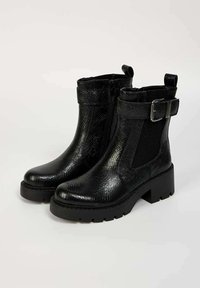 Bottes noires à la cheville en simili cuir texturé, avec un panneau élastique sur le côté, un accent de boucle et un talon épais avec une semelle robuste.