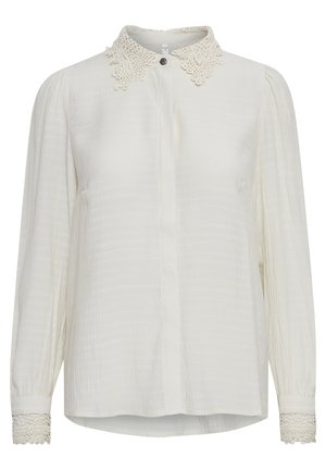 Witte blouse van een gestructureerde stof, met een scalloped kanten kraag en kantaccenten op de mouwen. Lange mouwen en knoopsluiting.