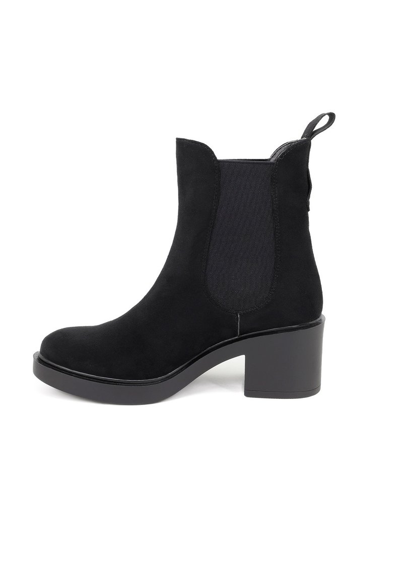 Stivale alla caviglia in suede nero con pannelli laterali elastici, punta arrotondata e tacco spesso. Presenta un'etichetta sul retro per una facile calzata.