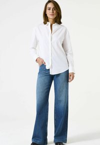 Witte button-up shirt met een kraag, gecombineerd met lichtblauwe wijde denim jeans. Soepele stoftextuur; casual pasvorm met functionele zakken.