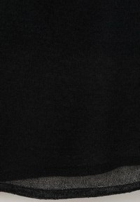 Tissu tricoté noir avec une texture lisse, présentant un tissage légèrement lâche. Le bord inférieur a une finition subtilement transparente.