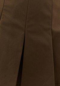 Tissu brun foncé avec un pli vertical central, montrant une texture lisse et un léger éclat sur le matériau.