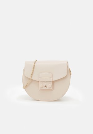 Okrągła kremowa torba ze skóry z klapą, złotym łańcuszkowym paskiem i wyraźnym zdobieniem z przodu. Gładka faktura i minimalistyczny design.