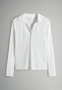 Maglietta bianca a maniche lunghe con colletto e scollatura a V; realizzata in tessuto liscio con un design pulito e senza motivi o accenti visibili.