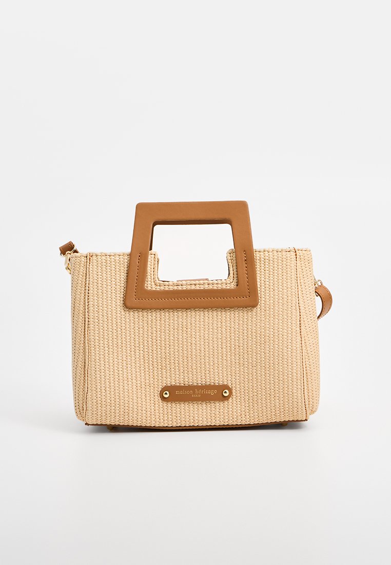Beige geweven tas met een vierkante bruine handgreep, gouden accenten en een logo plaat. Compacte rechthoekige vorm met een gestructureerd oppervlak.