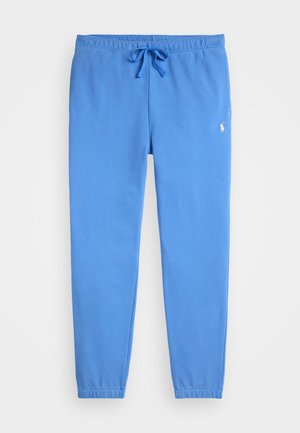 Blauwe sweatpants met een elastische tailleband en een trekkoord. Bevat taps toelopende benen en een klein wit logo aan de bovenlinke kant.