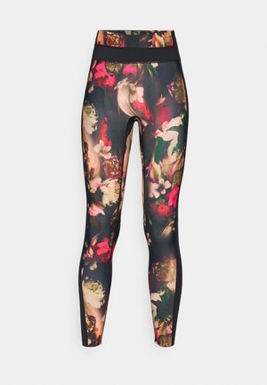 Virágmintás leggings, magas derékkal, élénk rózsaszín, zöld és fehér virágokkal, sötét háttér előtt.