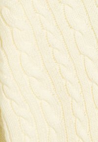 Ein kabelgestrickter Pullover aus weichem, hellgelbem Stoff. Besitzt erhabene, gedrehte Zopfmuster, die ein strukturiertes Erscheinungsbild erzeugen.
