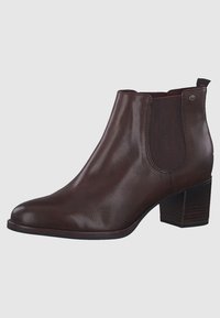 Braune Leder-Ankle Boots mit spitzem Zehenbereich, elastischen seitlichen Einsätzen und einem gestapelten Absatz. Glatte Textur mit leichtem Glanz und minimalem Zubehör.