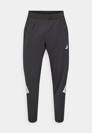 Pantaloni atletici negri cu picioare conice, talie elastică, buzunare laterale și detalii albe cu logo și dungi. Confecționați dintr-un material neted și ușor.