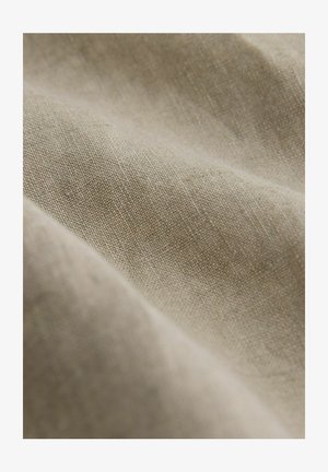 Prírodná béžová tkanina s textúrovaným tkaním, zobrazujúca jemné variácie vo farbe a mäkký, mierne drsný povrch.