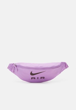 Paarse Nike heuptas met een gebogen ontwerp. Voorzien van een opvallend zwart "AIR"-logo en ritssluiting. Gladde stoftextuur.