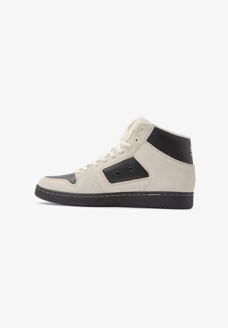 Högsneaker med krämfärgad mocka och svarta läderpaneler, svart sula och krämfärgade snören, visad i höger profilsynvinkel mot vit bakgrund.