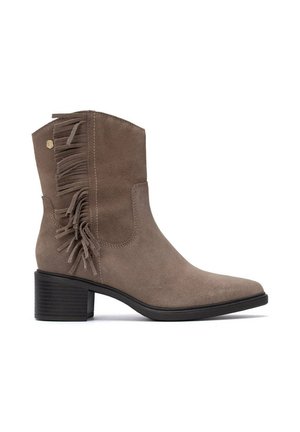 Bota de ante taupe hasta el tobillo con tacón cuadrado y flecos decorativos en el lateral exterior.