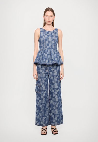 Džínový dvojdielny outfit s peplum topom s kockovaným vzorom a nohavicami s širokými nohavicami a bočnou kapsou. Paleta farieb: rôzne odtiene modrej.