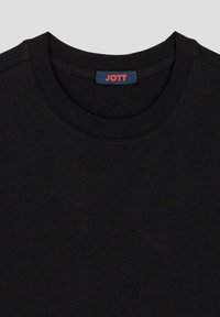 Schwarzes Baumwoll-T-Shirt mit Rundhalsausschnitt. Zeigt ein blaues Etikett mit "JOTT" in roter Schrift am Kragen. Glatte Textur.