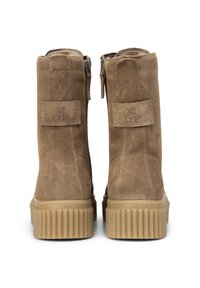 Bottes en suède marron à la cheville avec une surface texturée, dotées de fermetures éclair sur les côtés et d'une semelle en caoutchouc nervurée. Marquage sur le talon.