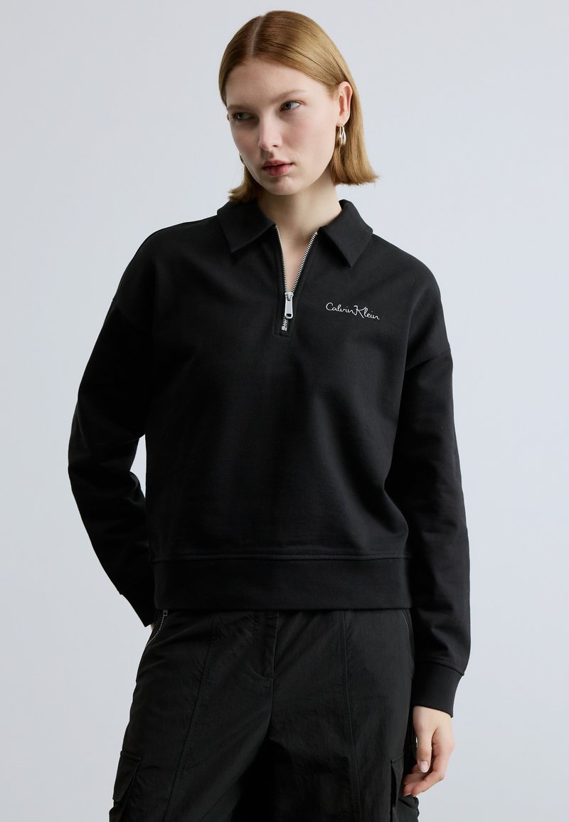 Felpa nera con zip in cotone, con colletto, orlo a coste e logo ricamato sul petto. Maniche lunghe con vestibilità comoda.