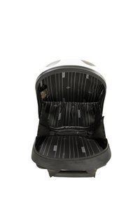 Mochila negra con exterior blanco, cierre de cremallera y interior a rayas negras. Cuenta con múltiples bolsillos y bandas elásticas para la organización.
