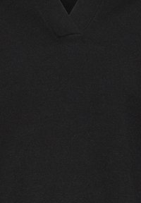 Juodas megztinis su V formos iškirpte. Audinys atrodo minkštas ir lygus, su nuosekliu ir tolygiai išsidėsčiusiu raštu.