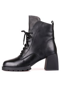 Bottine en cuir noir avec lacets à l'avant, bout arrondi, talon moyen épais, et languette de traction sur la boucle du talon sur fond blanc.