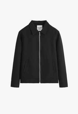 Veste noire zippée avec col et deux poches avant inclinées, présentée sur un fond blanc.