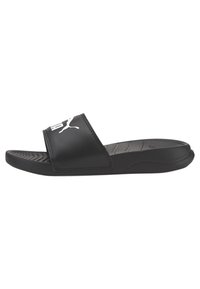 Black slide sandal with a wide strap, textured footbed, and a white logo. Material appears smooth, with a low-profile design and rubber sole.