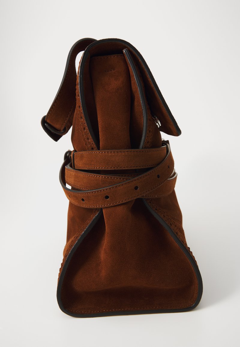 Brun mockastväsk med en vikt topp och ett lindat band. Kantad med svart trim, med en slät yta och en strukturerad form.